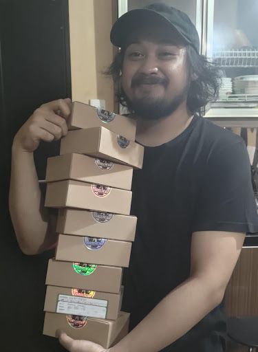 Working for a Remote Company with Ezra of Smile.io - Ezra holding boxes he will ship out soon 