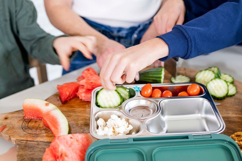 kids hands reaching inside their lunch boxes