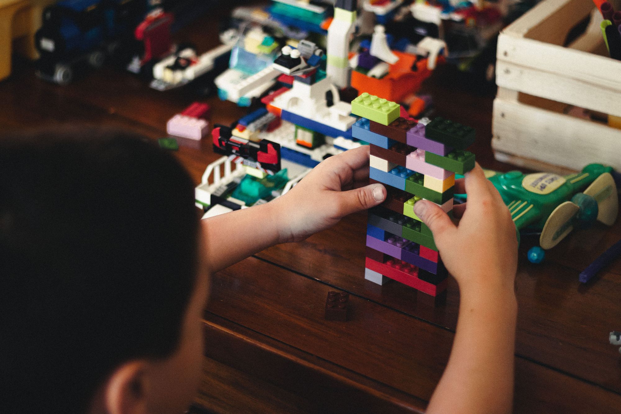 little boy building a LEGO tower