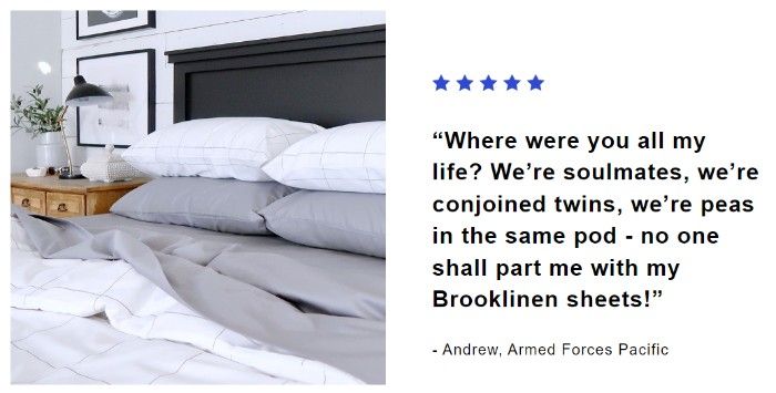 A screenshot of Brooklinen’s email showing a customer testimonial: “Where were you all my life? We’re soulmates, we’re conjoined twins, we’re peas in the same pod - no one shall part me with my Brooklinen sheets!” - Andrew, Armed Forces Pacific. There is an image of a bed with grey sheets and a white, plaid comforter. 