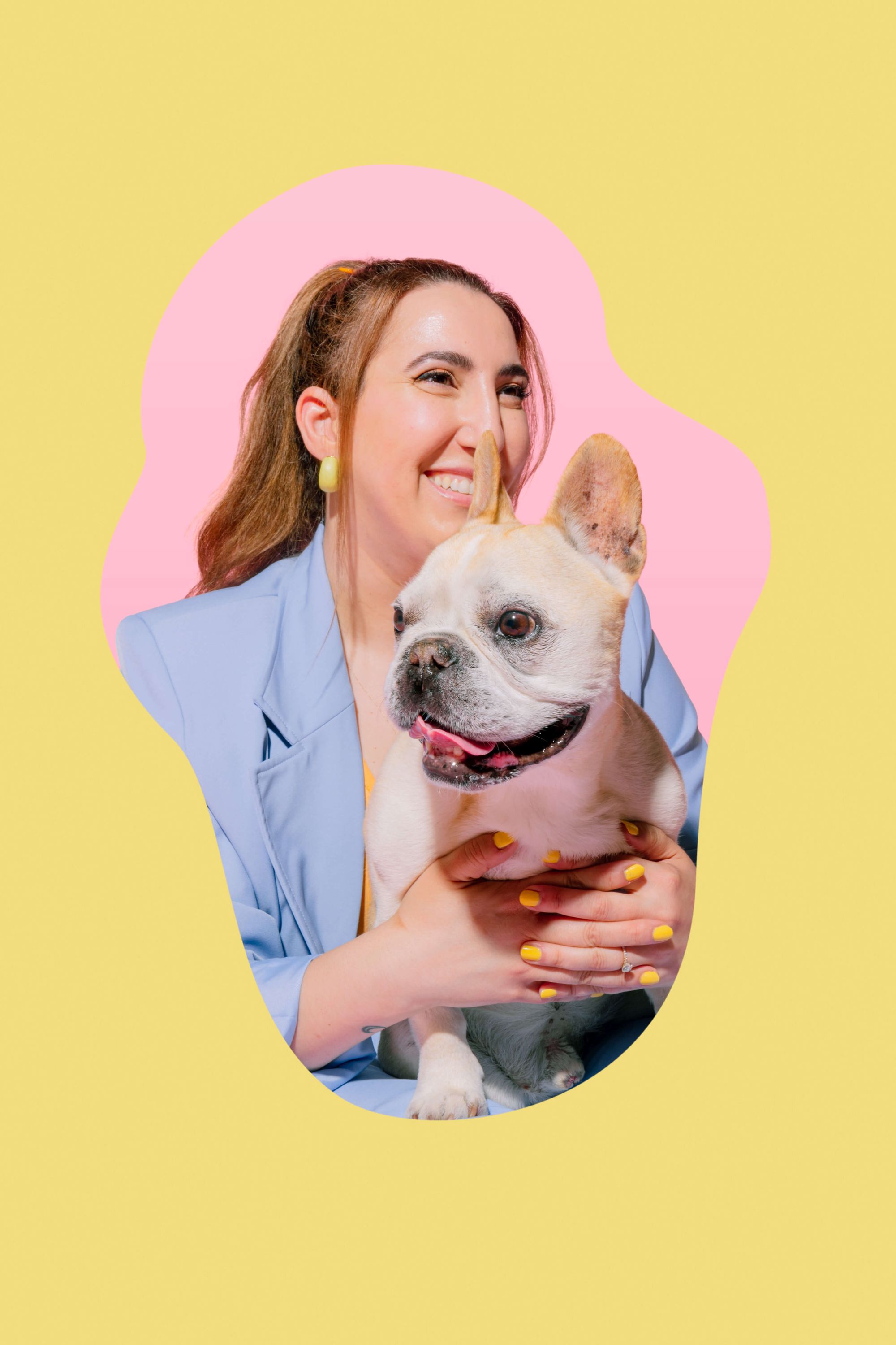 An image of the founder, Leda, smiling and looking off into the distance while holding her French Bulldog, Handsome. Handsome has white fur and is sticking out his tongue. 