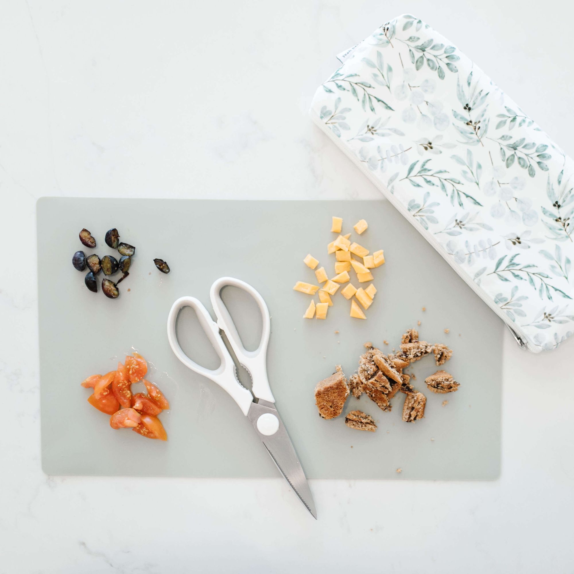 flat lay photo of a bag with scissors and food on the table 