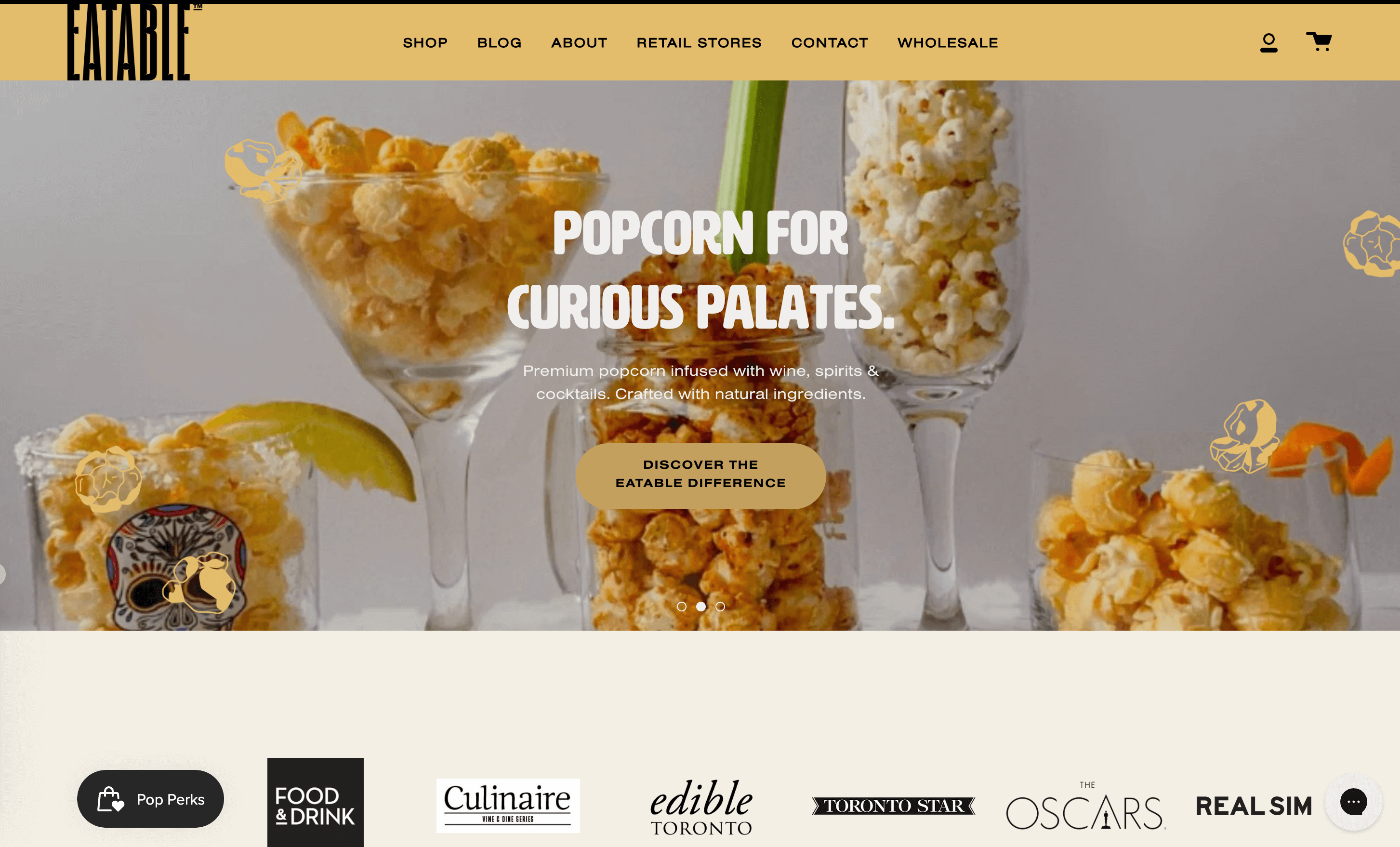 A screenshot of EATABLE’s homepage showing an image of alcohol glasses filled with popcorn. The title reads Popcorn for Curious Palates. 